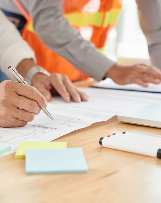 Manos de ingenieros mineros revisando documentos realizando asesoría técnica en la industria minera